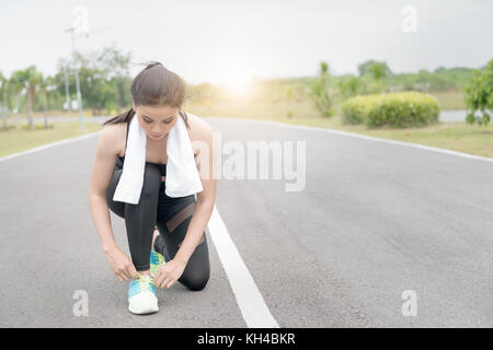 Ausführen von Athlet Mädchen. Portrait von jungen Sport Mädchen Schnürsenkel binden auf der Straße. gesunder Lebensstil und Sport Konzepte. Stockfoto