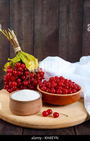 Red viburnum in einer Keramikschale, Zucker, ein paar Beeren für Tee, Marmelade. Stockfoto