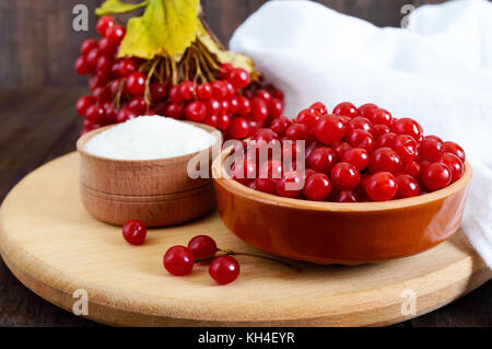 Red viburnum in einer Keramikschale, Zucker, ein paar Beeren für Tee, Marmelade. Stockfoto