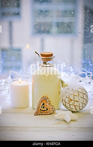 Eine Flasche Milch, Bälle und eine Kerze auf dem Tisch Stockfoto