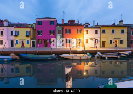 Fischer Häuser und kleine Boote auf dem Kanal auf der Fondamenta della Pescheria, Burano in der Lagune von Venedig kurz nach Sonnenuntergang wider. Stockfoto