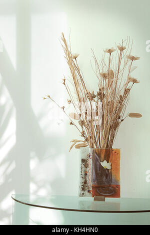 Eine Vase mit verschiedenen trockenen Blume auf den Glastisch Stockfoto