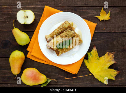 Duftende Süße Pfannkuchen mit karamellisierten Birnen auf einem weissen Teller. die Ansicht von oben Stockfoto