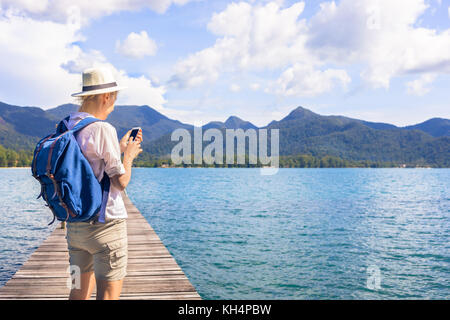 Weibliche Reisende mit Rucksack an Smartphone Karte suchen während des Aufenthalts in einer tropischen Insel, Ferienhäuser reisen Abenteuer Stockfoto