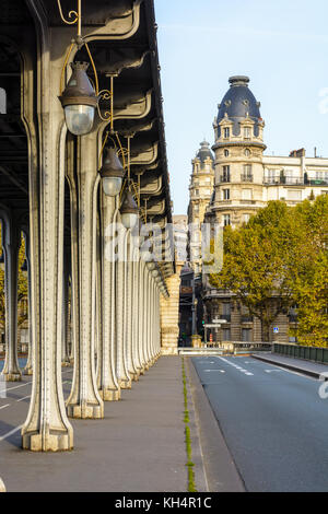 Ausrichtung von Metall Säulen der U-Bahn Anschluss des Bir Hakeim - Brücke in Paris und einem Haussmann-gebäude Stil Gebäude mit einer Kuppel in der angehoben Stockfoto