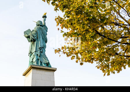 Hintere Ansicht von unten der Freiheitsstatue in Paris, mit gelben Blätter im Vordergrund. Stockfoto