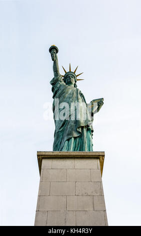 Vordere Ansicht von unten der Freiheitsstatue in Paris gegen einen hellblauen Himmel. Stockfoto