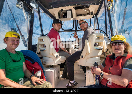 Vier Personen sitzen in einem Schnellboot und kehren von einer Angeltour zurück, lächeln, mit Blick auf die Kamera, Vancouver Island, British Columbia, Kanada Stockfoto