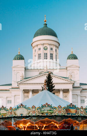 Helsinki, Finnland. xmas Markt Am Senatsplatz mit Urlaub Karussell und Wahrzeichen der lutherischen Kathedrale und Denkmal der russischen Kaiser alexan Stockfoto