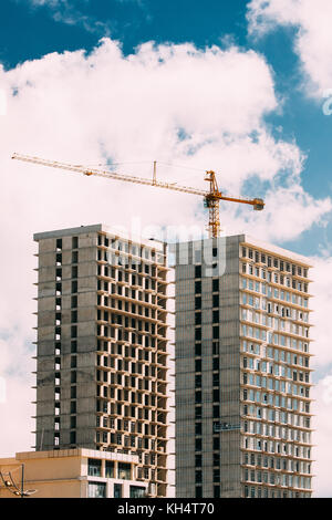 Bau kran ist in den Bau eines neuen mehrstöckigen Klassenfahrten Häuser in sonnigen Sommertag beteiligt. Stockfoto