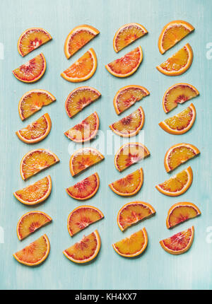 Frische saftige Blutorange Schichten in Zeilen angeordnet, blauer Hintergrund Stockfoto