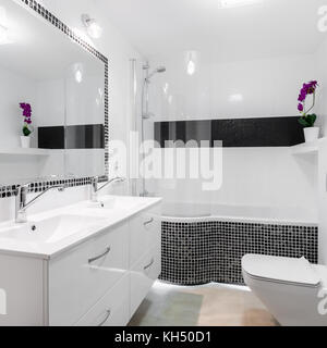 Helles Badezimmer Interieur mit einfachen und eleganten schwarzen und weißen Fliesen Stockfoto