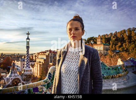 Barcelona Signatur Stil. Elegante reisenden Frau im Mantel an Park Güell in Barcelona, Spanien in die Ferne suchen Stockfoto