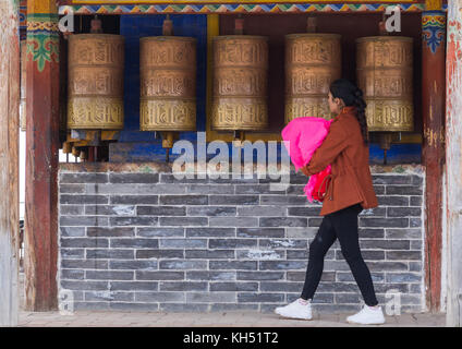 Tibetischen Pilger Frau Drehen Gebetsmühlen in Shachong Monastery, Provinz Qinghai, Wayaotai, China Stockfoto