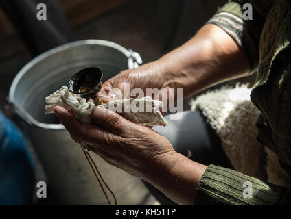 Tibetische freiwillige Reinigung eine Butter Lampe in Shachong Monastery, Provinz Qinghai, Wayaotai, China Stockfoto