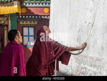 Mönche die Wände eines Tempels in Kloster Rongwo, Tongren County, Longwu, China Stockfoto