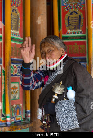 Tibetischen Pilger Frau riesige Gebetsmühlen drehen in Labrang Kloster Labrang, Provinz Gansu, China Stockfoto