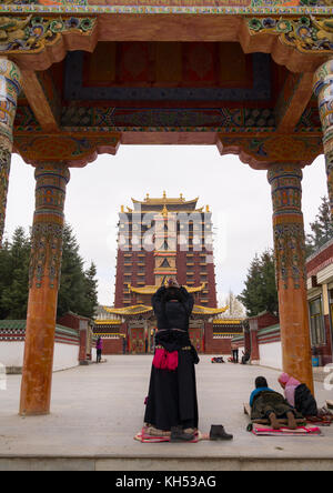 Tibetischen Pilgern beten und niederwerfen vor Hezuo Kloster und seine Milarepa Tower, Provinz Gansu, Hezuo, China Stockfoto