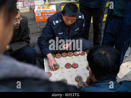 Gruppe von Menschen spielen mah-jong in der Straße, Provinz Gansu, Lanzhou, China Stockfoto
