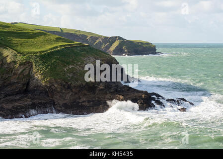 Eine stürmische See sendet die Wellen gegen die Felsen in der Nähe von Port Isaac an der Küste von North Cornwall, UK, auf einem sonnigen Herbsttag. Stockfoto