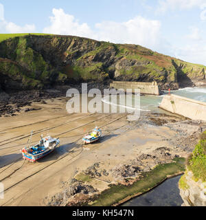 Strände Fischerboote auf dem Sand bei Ebbe im Hafen auf der North Cornwall Küstenort Port Isaac, Großbritannien Stockfoto