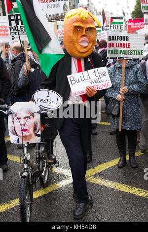 Ein langjähriger Demonstrant trägt eine selbstgemachte Trump-Maske und "Maybike" auf dem marsch für Palästina durch London zum 100. Jahrestag der Balfour-Erklärung Stockfoto
