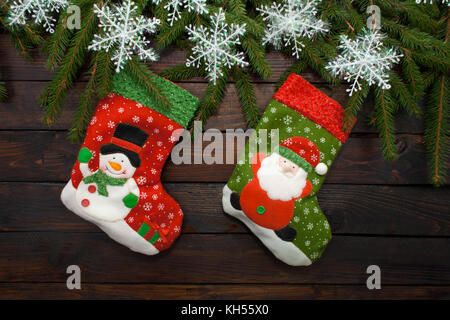 Grüne Weihnachten Baum auf einem dunklen Hintergrund. Neues Jahr Hintergrund mit Socken und weißen Schneeflocken. Ansicht von oben. Stockfoto