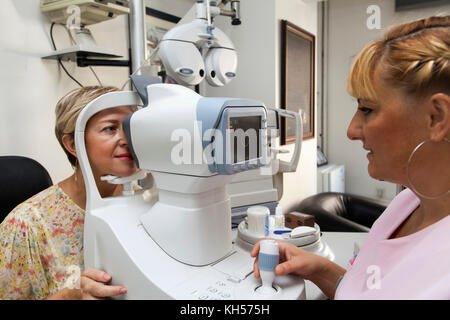 Junge Frau mit einem occular Hypertonie Kontrolle durch Pachymetrie Test an den Optiker Stockfoto