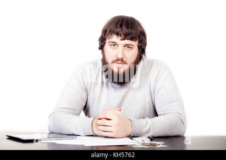Porträt der jungen Unternehmer in Bart, in die entspannte Position sitzen im Büro Tisch mit ansprechenden Look. Zuversichtlich männlichen Geschäft Person Stockfoto