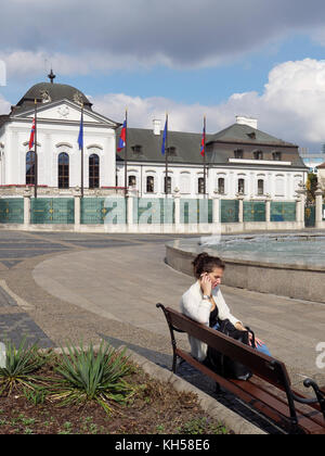 Frau mit Handy, Grassalkovich Palast und Brunnen in Hodzovo nam., Bratislava, Bratislavsky kraj, Slowakei, Europa Stockfoto