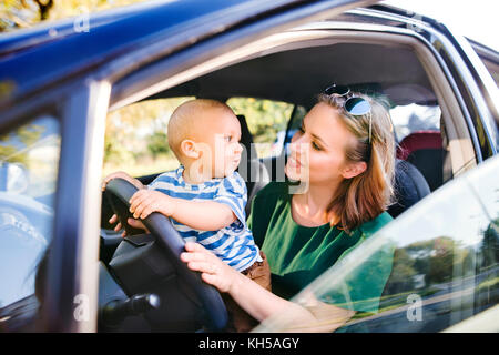 Junge Mutter mit ihrem kleinen Baby im Auto. Stockfoto