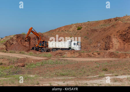 Bagger belädt einen LKW. Stockfoto