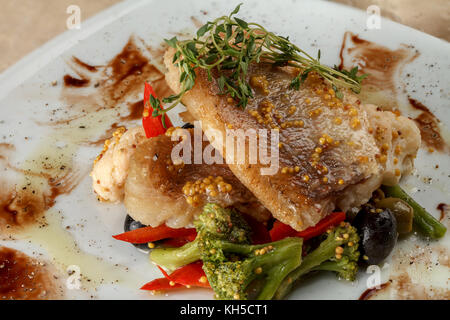 Gebratener weißer Fischfilets mit Blumenkohl und Brokkoli, mit Paprika und Oliven und Bohnen Stockfoto