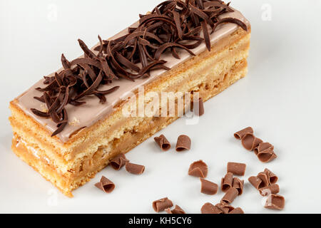 Sand Kuchen mit Karamell bestreut mit Schokolade auf einem weißen Teller. close-up. Stockfoto