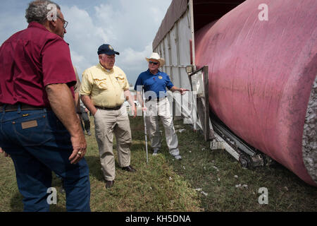 Gehen zurück mit Förderwagen Backup und Laden rund Module aus Baumwolle US-Landwirtschaftsminister Sonny Perdue Uhren als neue Mikrowelle Feuchtigkeitssensor misst die Last, wie es in den Anhänger, In der Kabine hat der Fahrer sofortige Ergebnisse des Scans und kann die Mocule zum Gin zur Verarbeitung oder zu anderen Bereichen zum Trocknen und Lagern an einem der besuchten Standorte bringen, um Schäden an der Landwirtschaft durch Hurrikan Harvey, von Houston nach El Campo, Texas, zu sehen. Am 21. September 2017. Er wurde von US-Repräsentantenhaus Landwirtschaft Ausschuss Vorsitzender K. Michael Conaway (TX Stockfoto