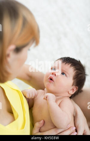 Seitenansicht der fürsorgliche Mutter und ihr Baby Baby an einander, Zeit gemeinsam zu Hause suchen Stockfoto