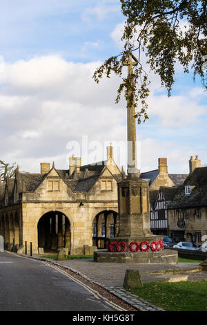 Kriegerdenkmal mit Mohn kraenzen durch alte Markthalle aus dem 17. Jahrhundert im historischen Cotswolds Dorf. Chipping Campden Cotswolds Gloucestershire England Großbritannien Stockfoto