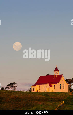 Vollmond hinter einer kleinen Kapelle, Westcoast Northland, North Island, Neuseeland Stockfoto