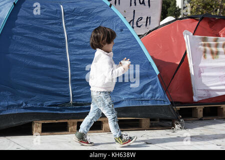 November 14, 2017 - Athen, Griechenland - ein Kind aus Syrien Spaziergänge vor Zelte am letzten Tag von hungerstreik am Syntagma-Platz. .14 syrische Flüchtlinge nahmen an einer zwei Wochen langen hungerstreik beginnen am 1. November. Sie verlangen nach Deutschland wiedervereint mit ihren Familienmitgliedern, die bereits in Deutschland niedergelassen hat verlegt werden. Der Hungerstreik mit einer Pressekonferenz beendet ist. (Bild: © Sopa über Zuma Draht) Stockfoto