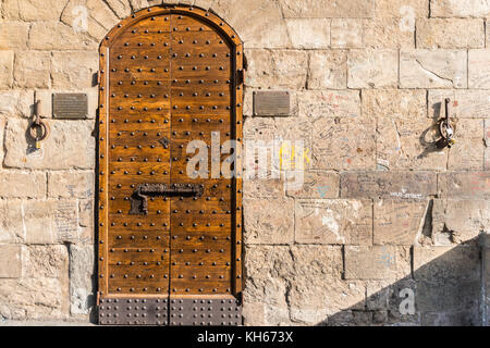 Mittelalterliche Tür mit Graffiti an der Wand auf der Ponte Vecchio, Florenz, Toskana, Italien Stockfoto