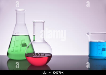 Labor Glas chemischen Behältern auf Glas Tisch isoliert Grau. Horizontale Komposition. Ansicht von vorn Stockfoto