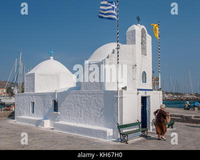 Kleine griechische Kapelle am Hafen von Ägina. Ägina ist eine griechische Insel in der Ägäis, die zu den Saronischen Inseln gehört. Stockfoto