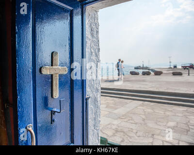 Kleine griechische Kapelle am Hafen von Ägina. Ägina ist eine griechische Insel in der Ägäis, die zu den Saronischen Inseln gehört. Stockfoto