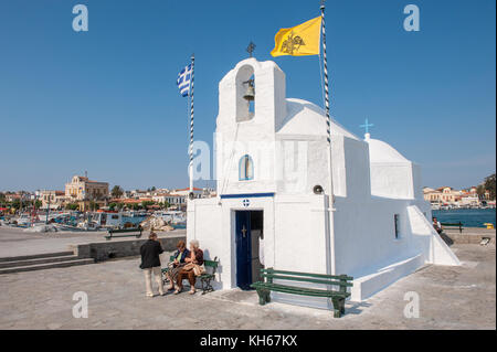 Kleine griechische Kapelle am Hafen von Ägina. Ägina ist eine griechische Insel in der Ägäis, die zu den Saronischen Inseln gehört. Stockfoto