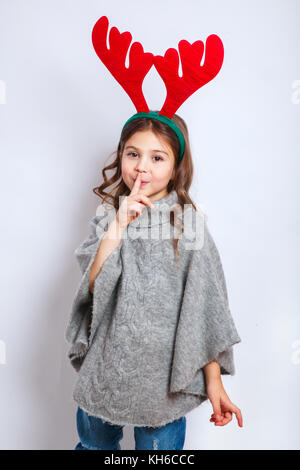 9 Jahre altes Mädchen hält Weihnachtsbaum vor frohe Weihnachtsbotschaft