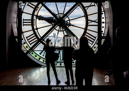 Touristen mit Blick über den Mechanismus der riesigen Uhr Musée d'Orsay Fassade Stockfoto