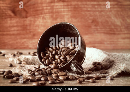 Verschüttete Kaffeebohnen aus der schwarzen Schale Stockfoto