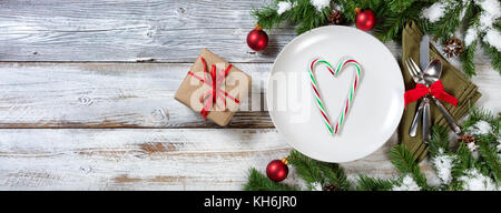 Urlaub Weihnachten Abendessen mit Geschenken auf rustikalen Tisch mit Schnee bedeckt Filialen Stockfoto