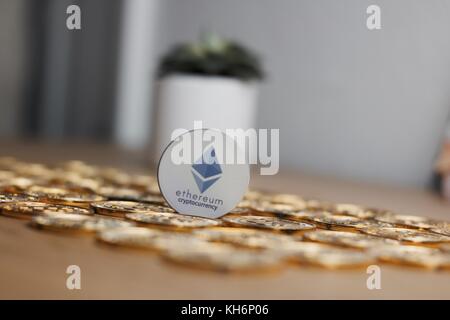 Digitale Währung physischen Grau des Astraleums Token auf Gold bitcoin Münzen in der Nähe von Blumen. Stockfoto