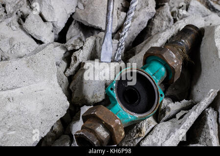 Abriss von Wänden. Elektrische hammer Helm und Gehörschutz liegen auf den Trümmern. alte Ziegel und renovierten Gebäude Wand. Grunzen auf dem Hintergrund Stockfoto